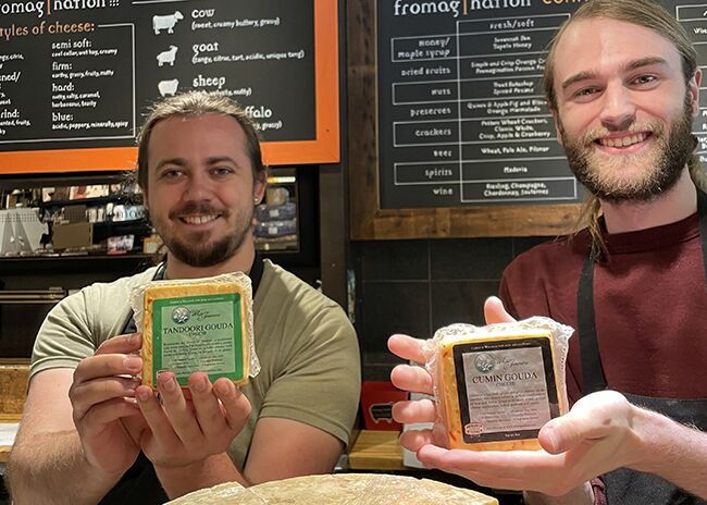 This is a picture of Fromagination cheesemongers with two White Jasmine Gouda cheeses.